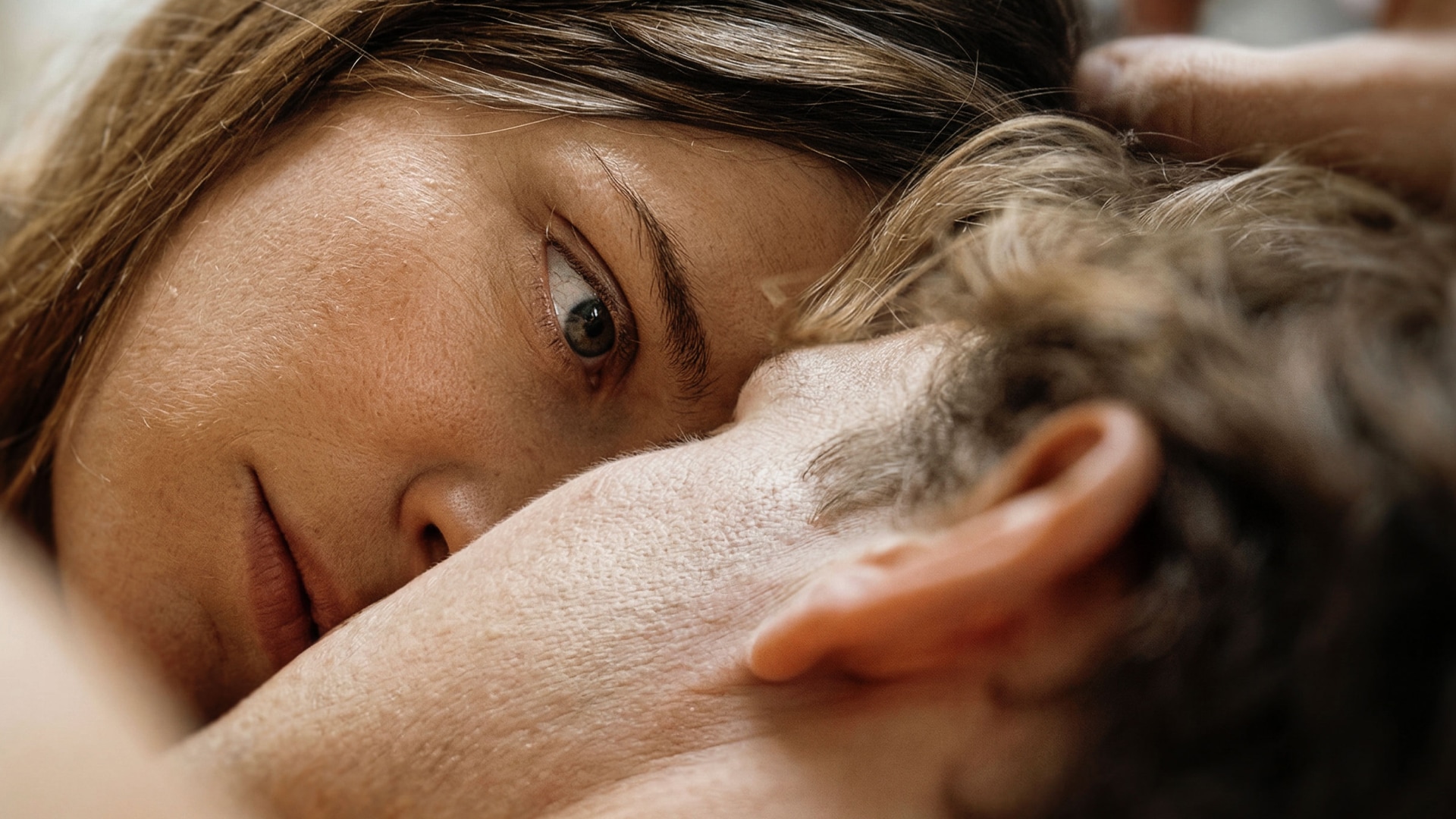 Woman with an open, pensive gaze rests her face against her partner's head