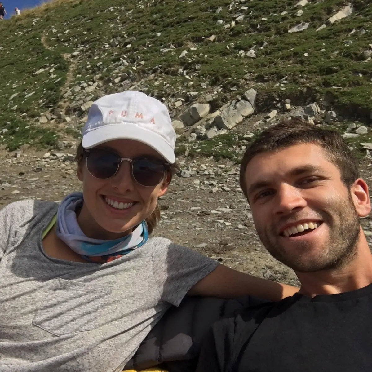 Xander and his wife smiling in a selfie on a mountain hike