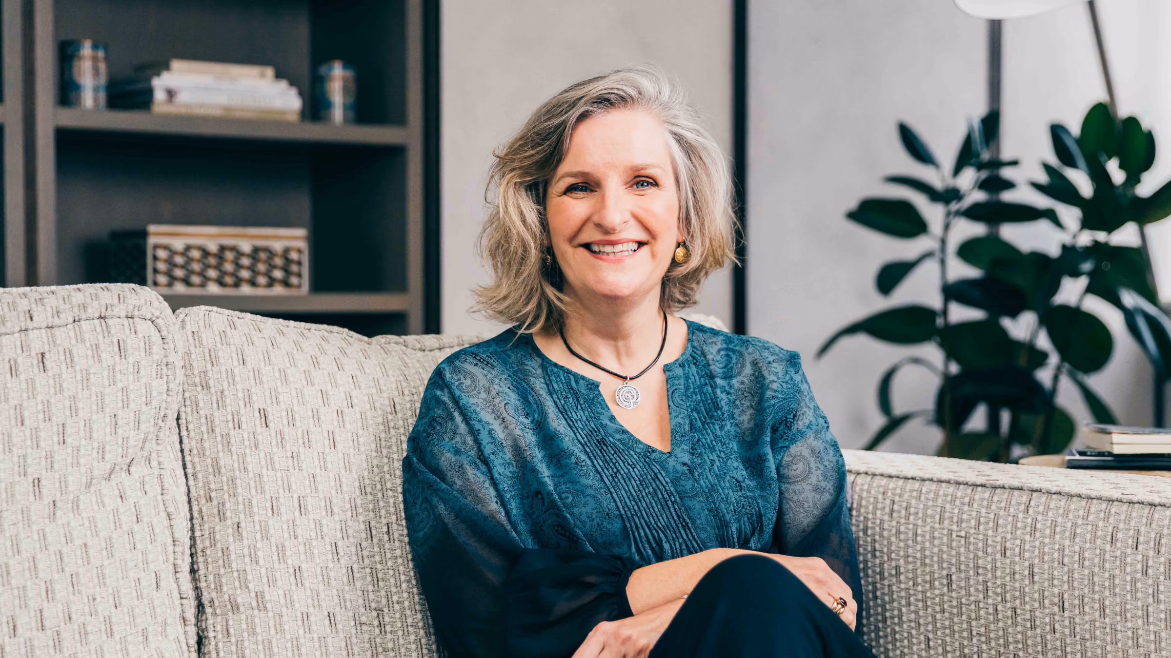 Amanda Barge, psychosexual and relationship therapist, smiling on a sofa in a teal top