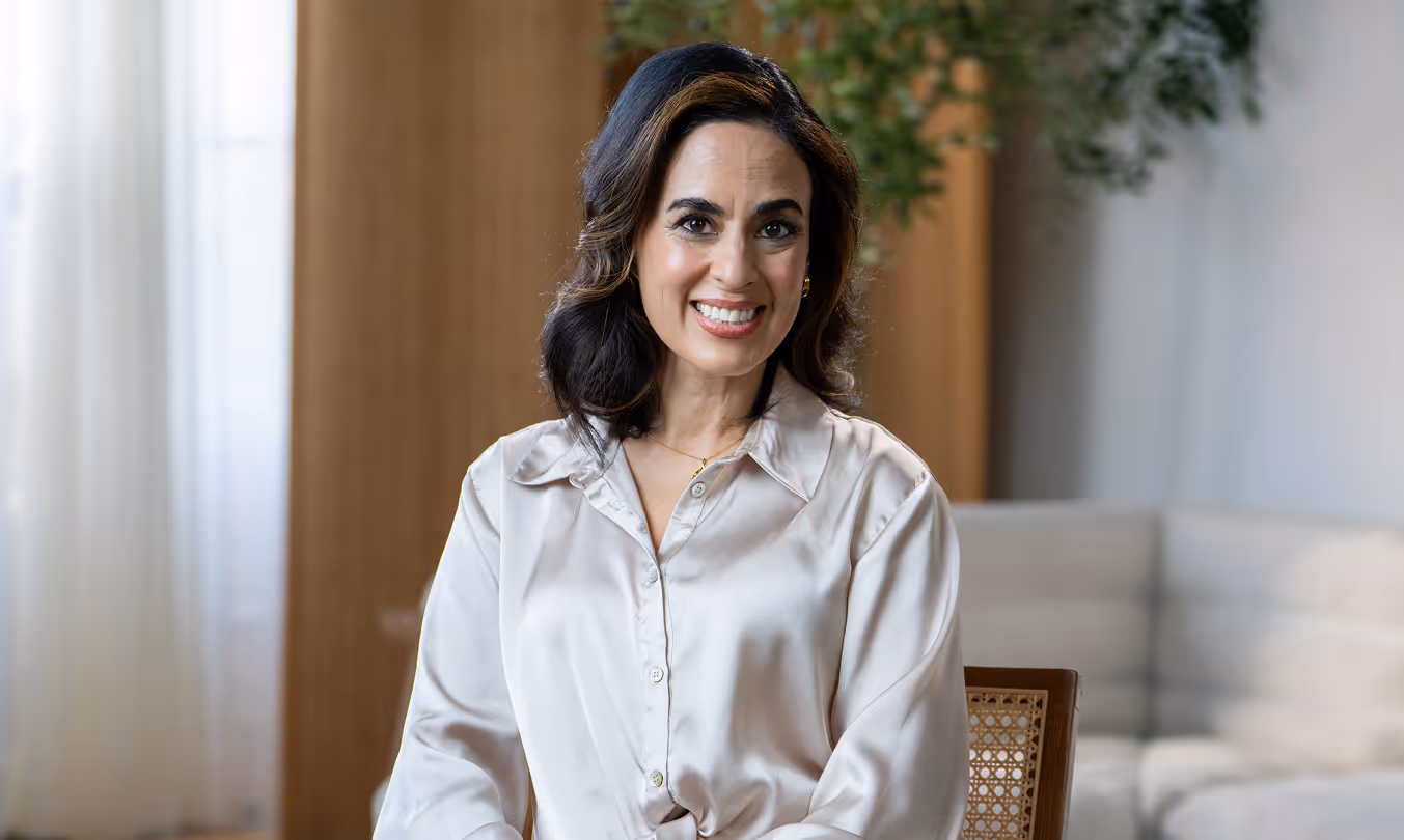 Dr. Shannon Chavez, clinical psychologist and sex therapist, smiling in a cream silk blouse in a softly lit room