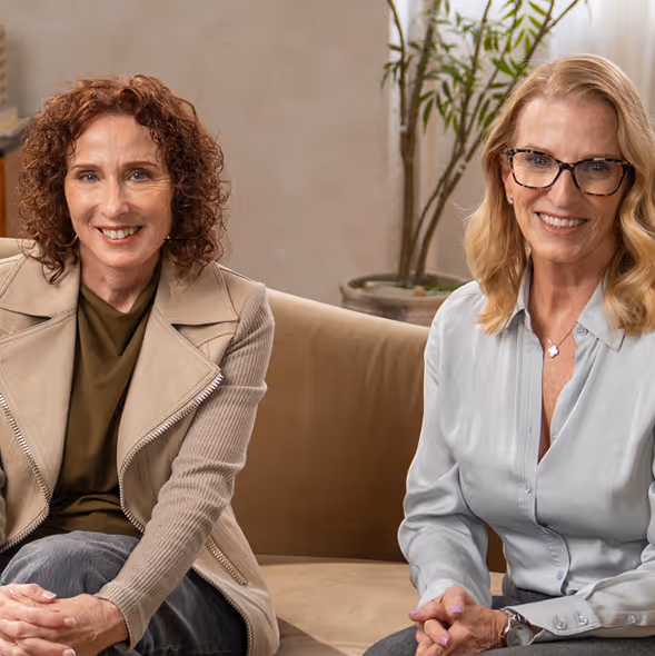 Dr. Laurie Mintz and Dr. Suzette Johnson sitting together on a sofa
